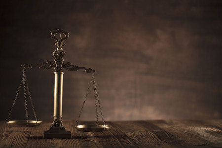 Law and justice theme. Scale of justice.  Wooden table and background.の写真素材