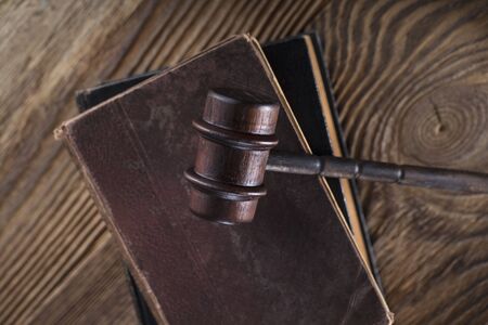 Law and justice theme. Gavel of judge and legal code on wooden table.