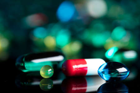 Pharmacy theme.  Set of different colorful pills on glass table. Background concept.