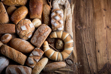 Mixed bread top view shot. Different fresh bread on old wooden table.