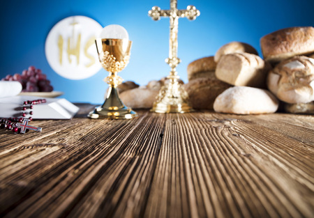 First Holy Communion. Catholic religion theme. Crucifix, Bible, bread on rustic wooden table and blue background.の写真素材