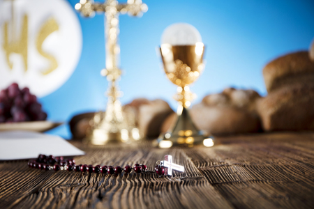 First Holy Communion. Catholic religion theme. Crucifix, Bible, bread on rustic wooden table and blue background.の写真素材