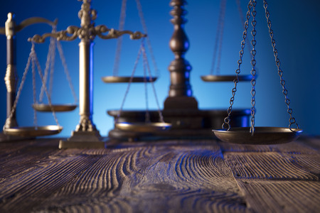 Lawyer, counselor office. Consultation with a lawyer concept.  Scale of justice on old wooden table and blue background.の写真素材