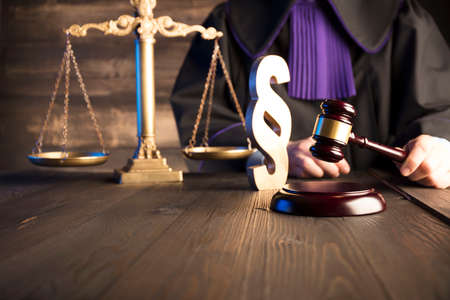 Law concept. Gavel in the hand of the jugde in toga.の写真素材