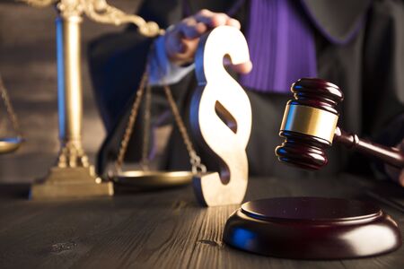 Law concept. Gavel in the hand of the jugde in toga.の写真素材