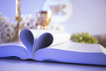 First Holy Communion. Catholic religion theme. Crucifix, Bible, bread isolated on white table and white background.の写真素材