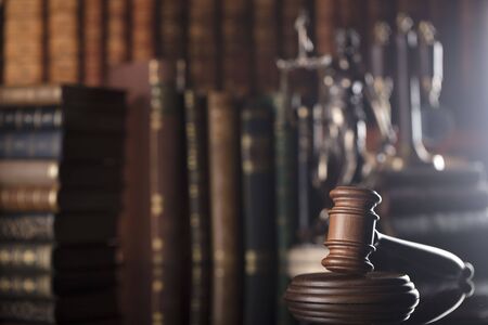 Gavel of the jugde and scale of justice in the court library. Wooden desk.の写真素材