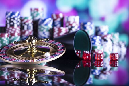 Roulette, chips, cards and dice on colorful bokeh.の写真素材
