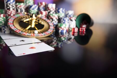 Roulette, chips, cards and dice on colorful bokeh.の写真素材