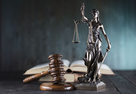Consultation with a lawyer concept. Statue of justice, mallet and book on green background.の写真素材