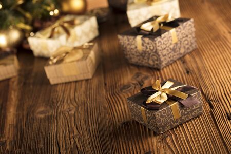 Golden Christmas decoration. Wooden table and background. Place for text.の写真素材