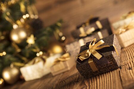 Golden Christmas decoration. Wooden table and background. Place for text.の写真素材