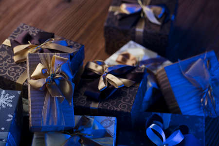 Presents in blue and gold aesthetics, rustic wooden table. Place for text.の写真素材