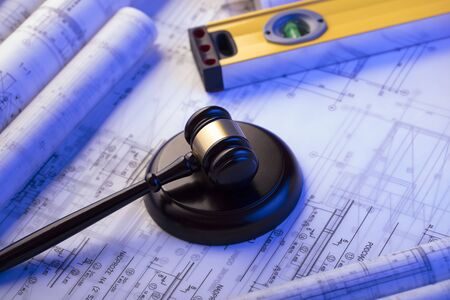 Labor and construction law. Gavel, helmet and blueprints.