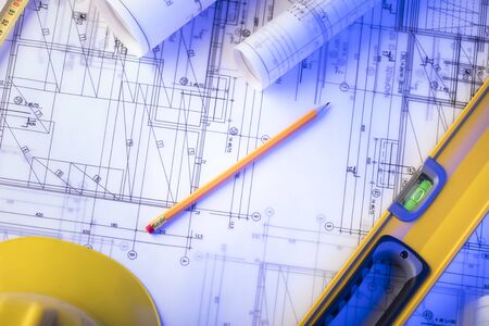 Work place of architect. Rolls of blueprints, libela and helmet of constructor. Place for text.の写真素材