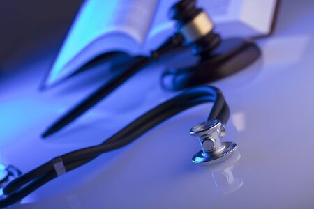 Medical law concept. Gavel, stethoscope, blue light. Place fort text.の写真素材