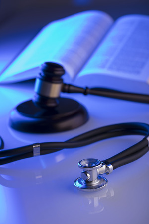 Medical law concept. Gavel, stethoscope, blue light. Place fort text.の写真素材