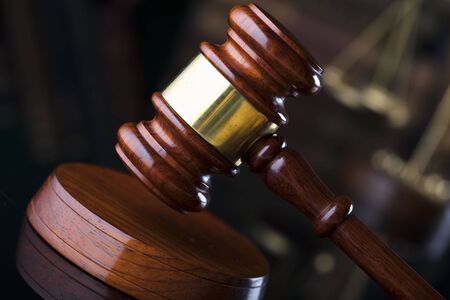 Law theme. Judgeâ€™s gavel on book background.