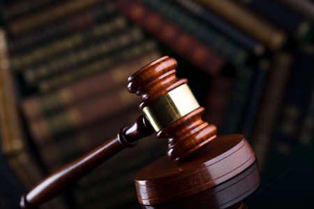 Law theme. Judgeâ€™s gavel on book background.
