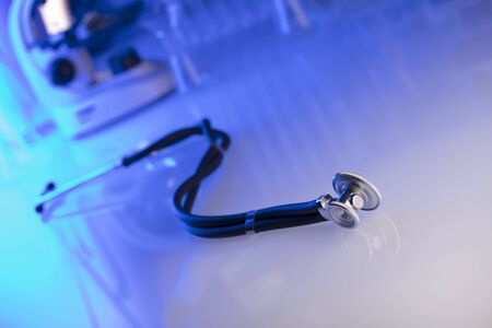 Healthcare, medical concept. Stethoscope, microscope,  lab glassware.  Blue background.の写真素材