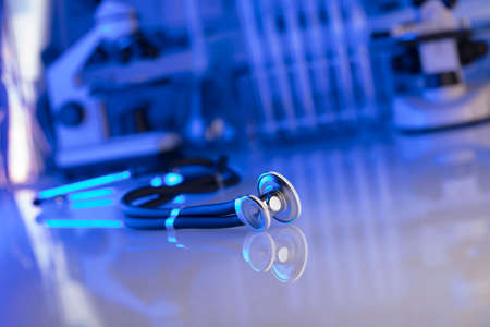 Healthcare, medical concept. Stethoscope, microscope,  lab glassware.  Blue background.の写真素材