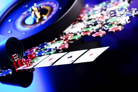 Casino concept. High contrast image of casino roulette, poker chips, dice. Blue light and place for...