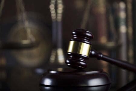 Law theme. Judge antique gavel. Bookshelf background.