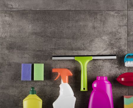 Spring cleaning concept. Colorful cleaning products on gray tiles. Place for typography.の写真素材