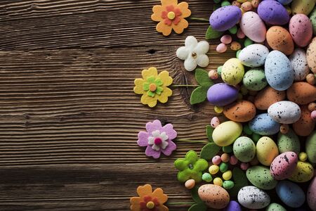 Easter background. Rustic wooden table. Tulips and spring flowers. Easter eggs. Colorful bokeh....