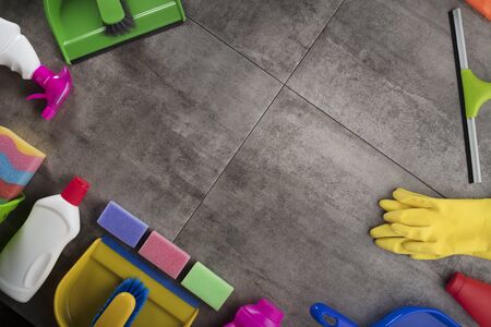 Spring cleaning concept. Colorful cleaning products on gray tiles. Place for typography.の写真素材