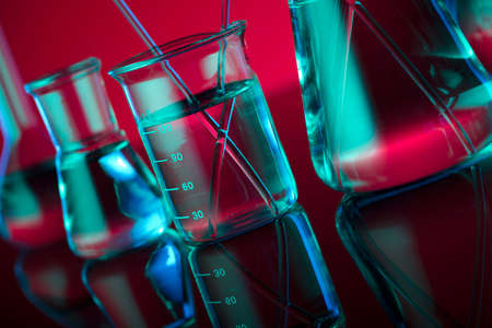 Chemical laboratory concept. Experiment with liquids.  Red background. Place for logo.の写真素材