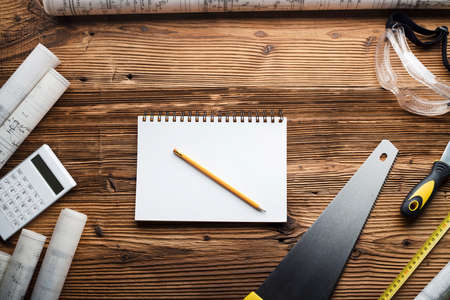 Contractor concept background. Top view. Place for typography. Blueprints and contractor tools and equipment on wooden table.の写真素材