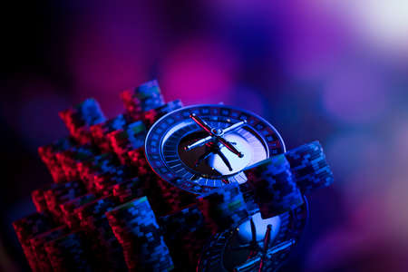 Gambling theme. Roulette and poker chips on colorful bokeh background.の写真素材