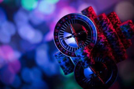 Gambling theme. Roulette and poker chips on colorful bokeh background.の写真素材