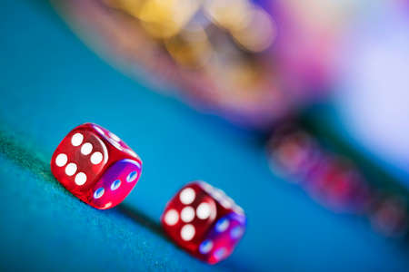 Gambling theme.  Dice, roulette wheel and poker chips on color bokeh background.の写真素材