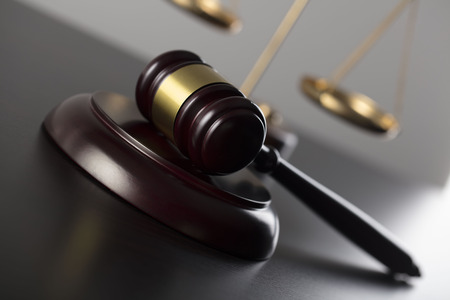 Law theme. Mallet oft the judge and scale of justice  â€“ symbols of the law. Gray background.