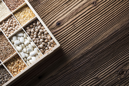 Healthy food and diet theme. Lentils, peas, beans, protein food in bowls, on a wooden table. Top view.の写真素材