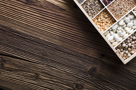 Healthy food and diet theme. Lentils, peas, beans, protein food in bowls, on a wooden table. Top view.の写真素材