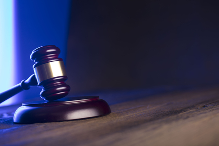 Law theme. Mallet of the judge on wooden desk. Blue light. Place for text.の写真素材