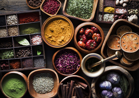 Set of colorful spices in different bowls on wooden tableの写真素材