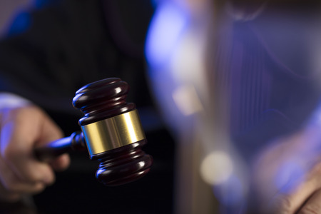 Judge in the courtroom. Male judge striking the gavel.の写真素材