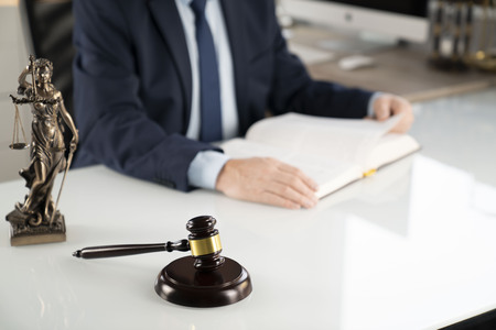 Lawyer concept background. Lawyer working at the office. Gavel, Themis statue and legal book on the...