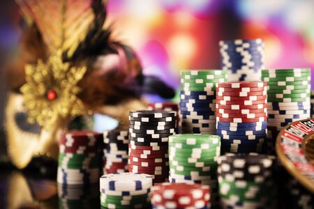 Gambling theme.  Roulette wheel and poker chips on color bokeh background.の写真素材