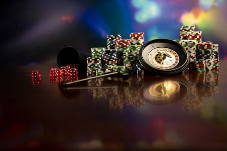 Casino theme.  Gambling games. Roulette, dice and poker chips on a colorful bokeh background.の写真素材