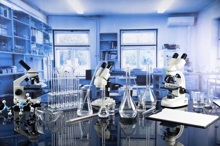 Modern scientific laboratory interior. Laboratory glassware and microscope on the glass table.の写真素材