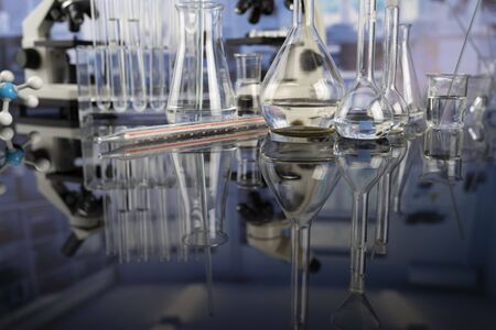 Modern scientific laboratory interior. Laboratory glassware and microscope on the glass table.の写真素材