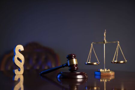 Law concept. Judgeâ€™s gavel, paragrahp sign and scale on dark background.