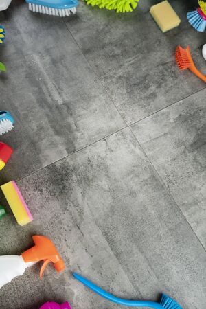 House cleaning concept. Top view of colorful cleaning products on gray tile floor.の写真素材