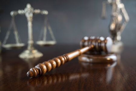 Law theme. Gavel of the judge, Themis statue and scale of justice on gray background.