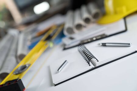 Architecture and construction concept. Empty notebook, rolls with building projects, spirit level ...